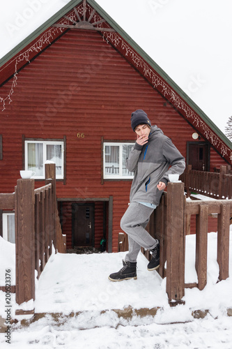 Wallpaper Mural Traveller boy smoking outdoor in front of the wood house in winter. Snowboarder lifestyle. Torontodigital.ca