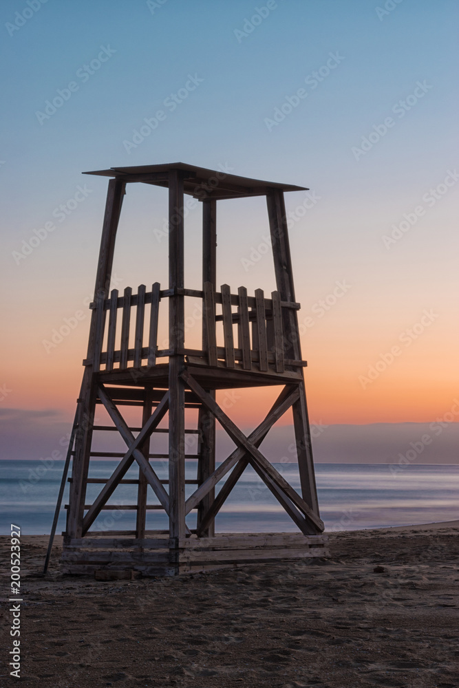 A lifeguard tower on the mediterranean beach at sunset