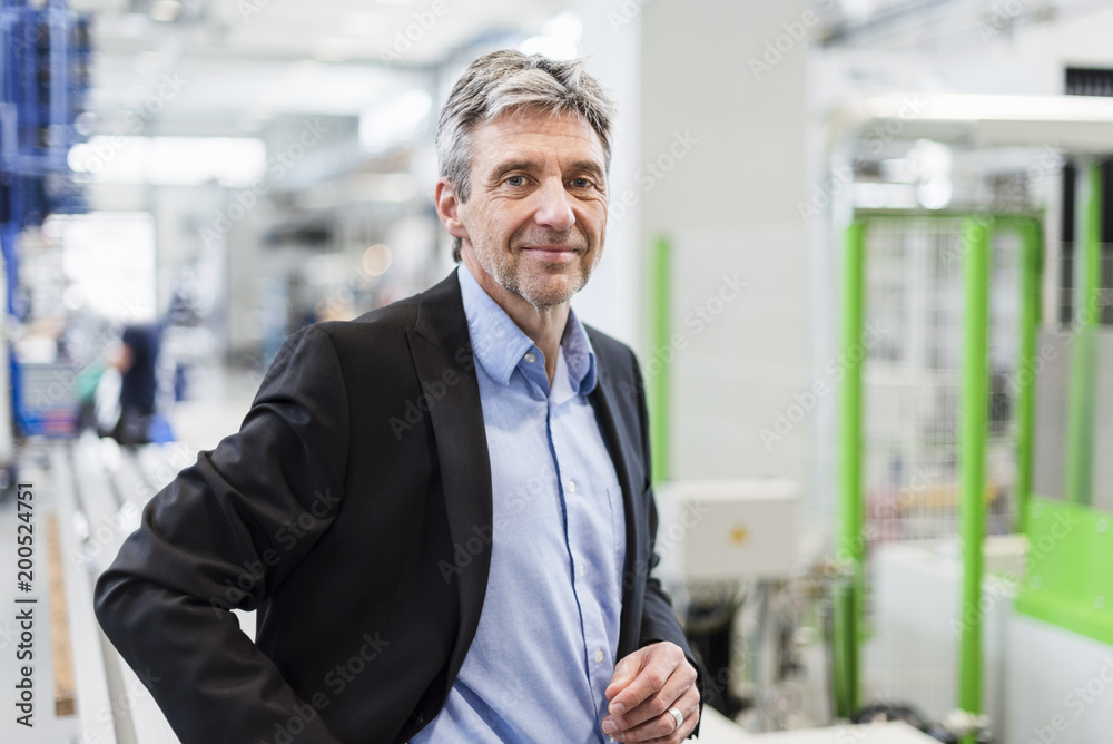 Smiling businessman in production hall Smiling businessman in production hall