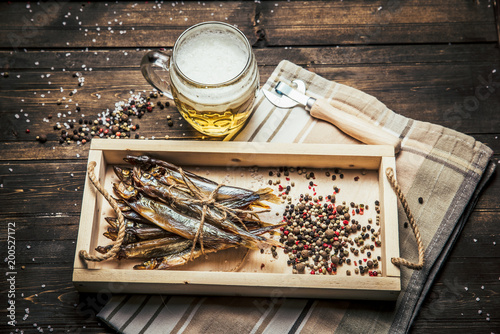 close-up dried fish, vintage glass of beer on a dark wooden background. Top view. Horizontal orientation.