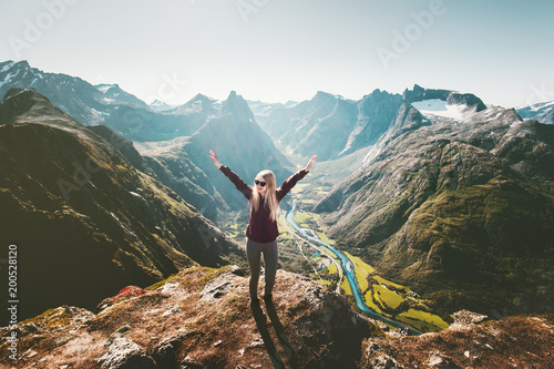 Woman raised arms standing on cliff in mountains landscape Travel healthy Lifestyle getaway trip adventure vacations in Norway