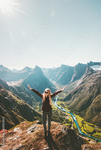 Happy woman raised hands standing on cliff mountain valley landscape Travel healthy Lifestyle adventure hiking vacations in Norway
