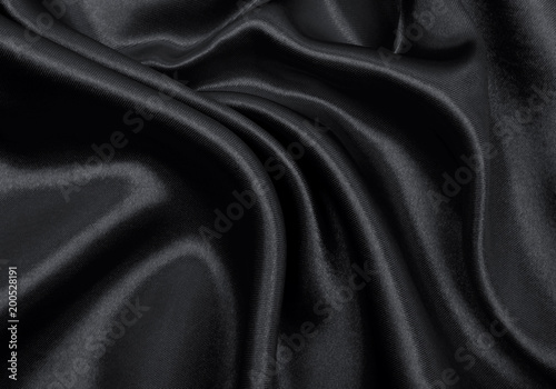 Smooth elegant black silk or satin texture as abstract background. Luxurious background design