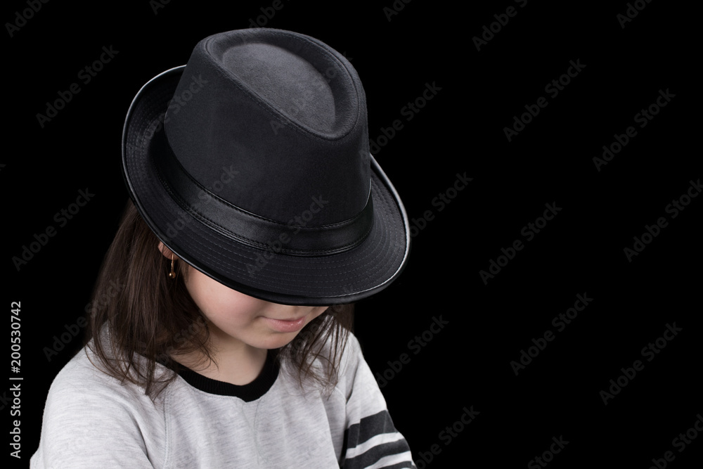 girl in cap with head tilted on black background girl in cap with head tilted on black background