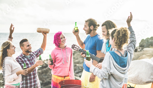 Happy friends dancing and drinking beers in camping party
