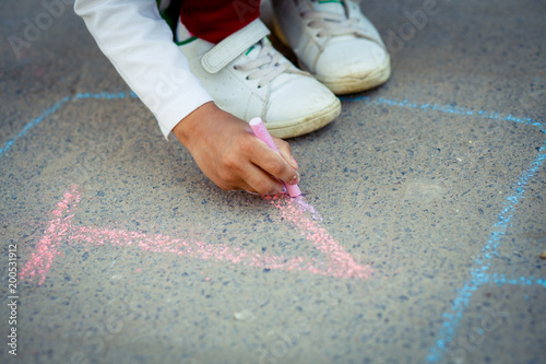 Hopscotch in a schoolyard on an asphalt floor with chalk drawings of numbers and squares as an icon of youth innocence and children playing a fun jumping game at recess or after elementary school. photo