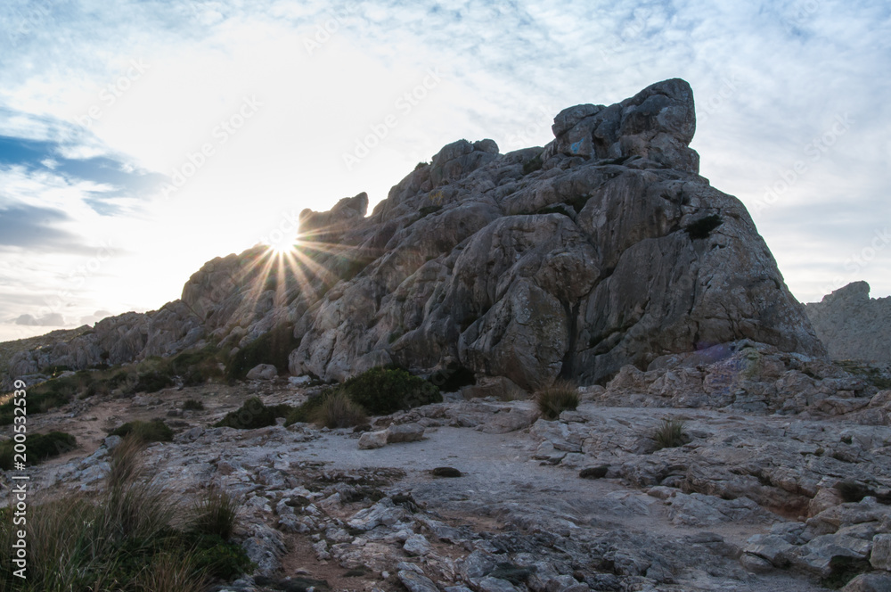 Sonnenstrahlen hinter einem Berg auf Mallorca, Balearen, Spanien, bei Sonnenuntergang