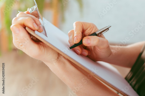 Tablou pe pânză caucasian woman's hands holds clipboard