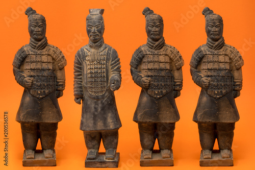 4 isolated Chinese terracotta warriors against a bright orange background