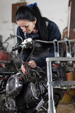 Girl worker in motorcycle repair shop