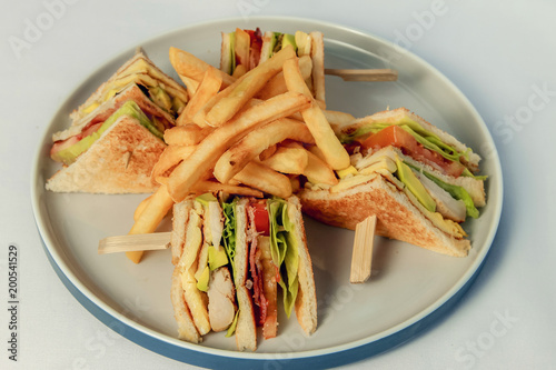 Tasty Club sandwich with meat bacon tomato cucumber and herbs