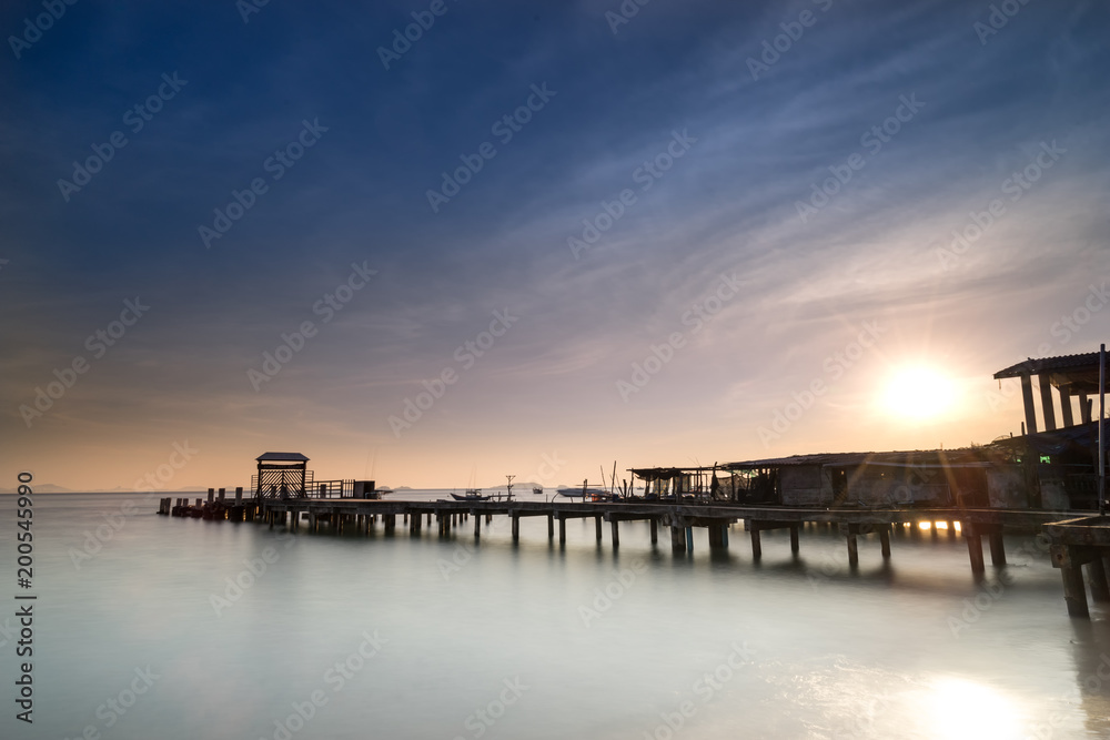 peaceful morning with wood dock in sea and sunrise star