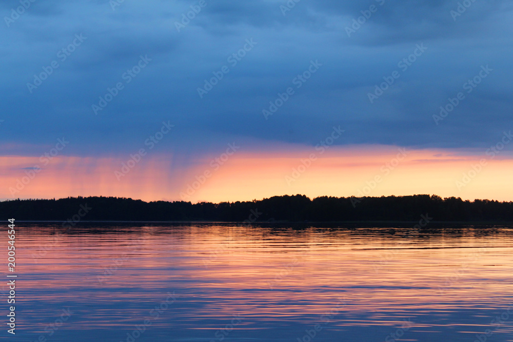 Sunset on the Vuoksa lake. It is small rain on the horizon.
