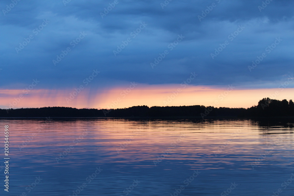 Sunset on the Vuoksa lake. It is small rain on the horizon.
