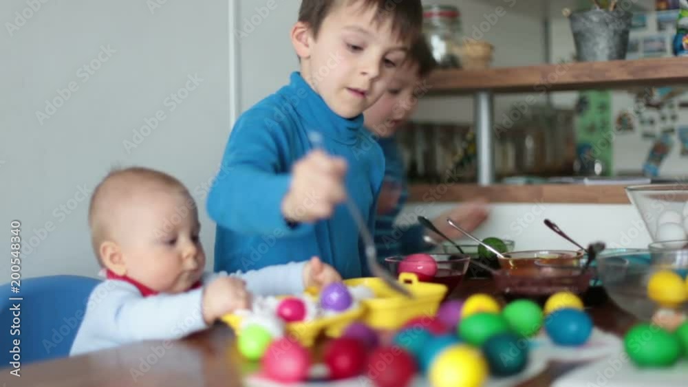 Three children, coloring and painting easter eggs at home for the holiday Three children, coloring and painting easter eggs at home for the holiday