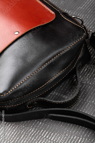 Messenger bag .leather black and red handmade bag on gray background.Closeup © vania_zhukevych