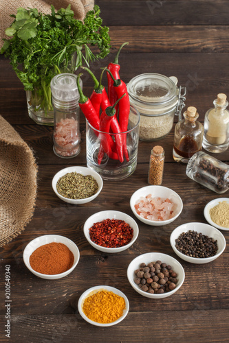Spices and herbs. Variety of spices and herbs on a dark wooden surface
