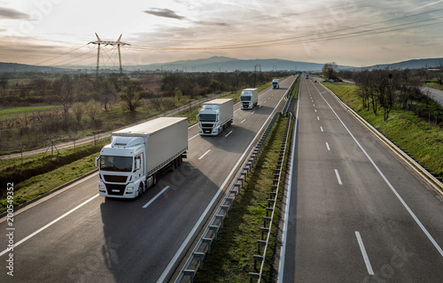 Foto Caravan or convoy of trucks in line on a country highway