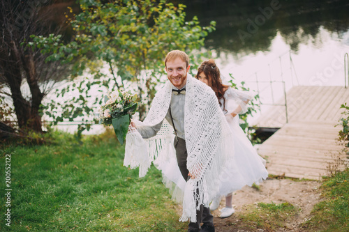 stylish bride and groom posing on the background of the river. funny photo photo