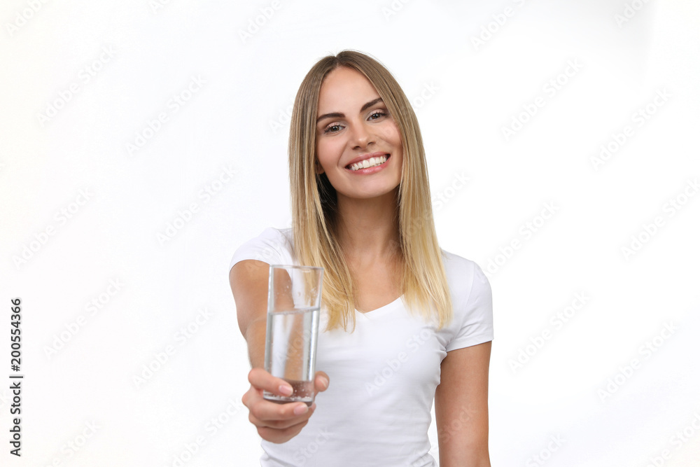 Hübsche blonde Frau präsentiert lachend ein Glas mit Wasser Hübsche blonde Frau präsentiert lachend ein Glas mit Wasser