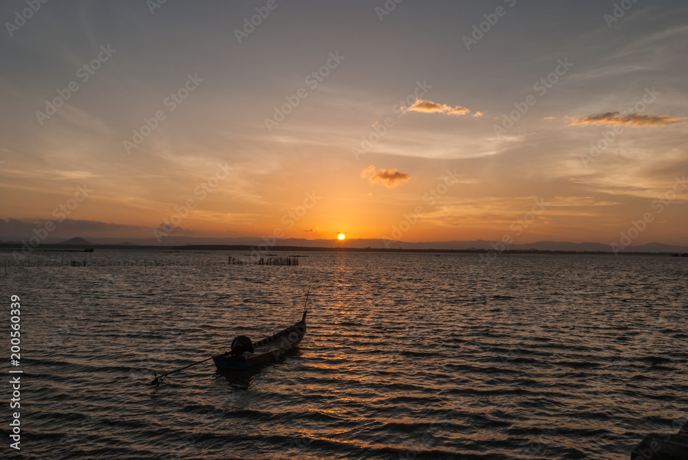 sunrise on the beach with wooden boat on the sea. sunrise on the beach with wooden boat on the sea.