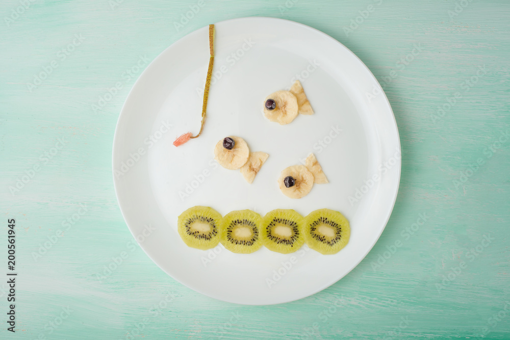 Fishes from fruit, creative from food on a white plate. Food Concept Fishes from fruit, creative from food on a white plate. Food Concept