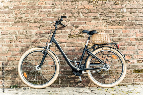 Black retro vintage bicycle with old brick wall.