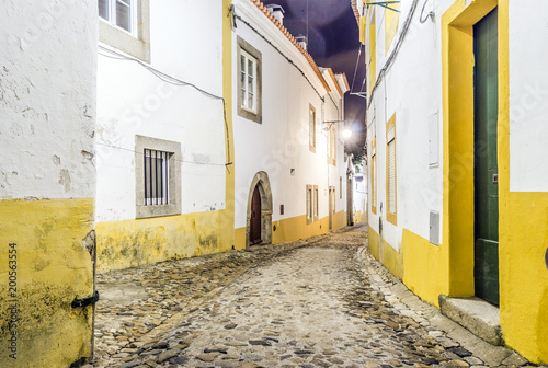 Narrow street with white and yellow houses in Evora  Alentejo  Portugal