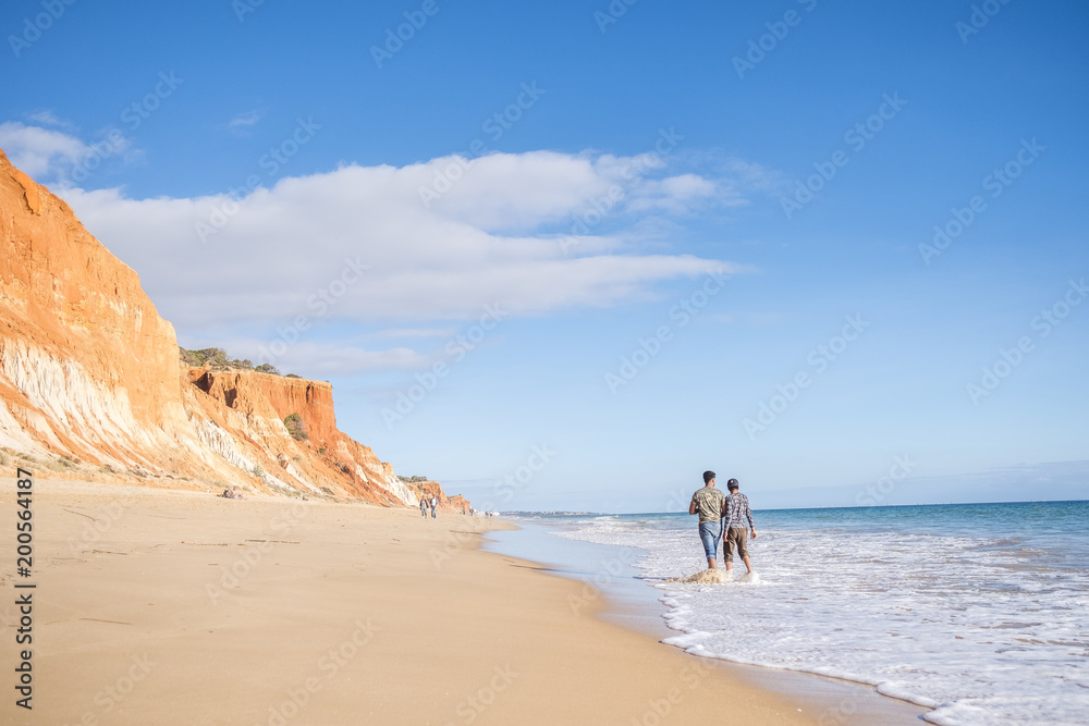 People walking on Falesia Beach with beautiful cliffs, Albufeira, Algarve, Portugal