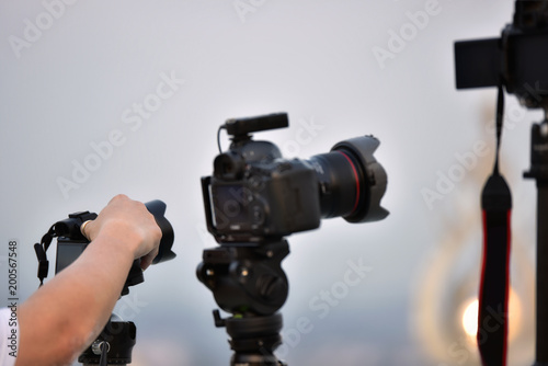 Cameraman working on professional camera , photographer hand adjusting camera.