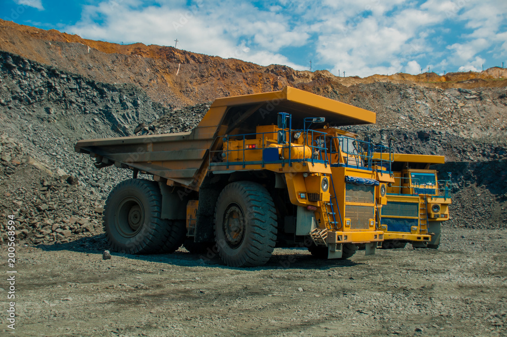 Obraz premium shipping. mining, delivery, transportation, loading, dump truck, truck, huge, heavy. Mining dump truck transports rock, iron ore along the side of the quarry.