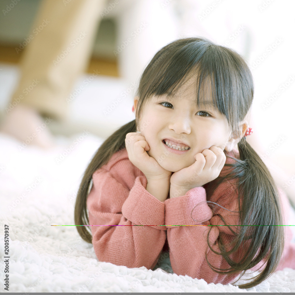 床に寝転び頬杖をつく女の子 Stock Photo Adobe Stock