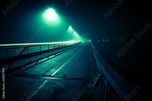 late evening image of a road in fog with road lights © Kilman Foto
