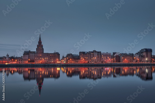 Night view on the illuminated riverside with reflection on the river in Riga © juriskraulis