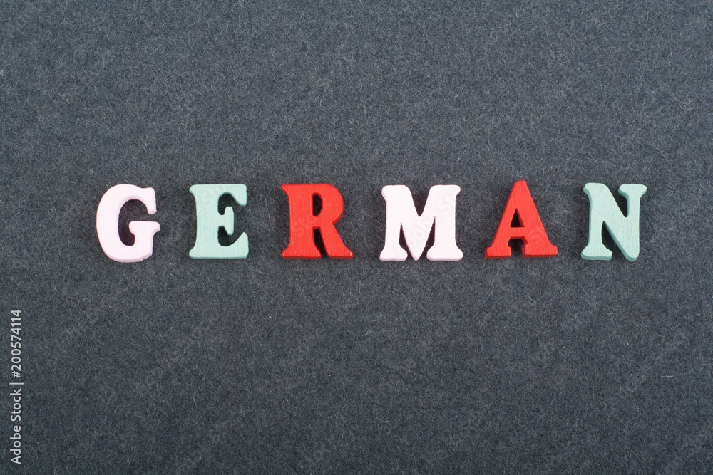 German word on black board background composed from colorful abc alphabet block wooden letters, copy space for ad text. Learning english concept. German word on black board background composed from colorful abc alphabet block wooden letters, copy space for ad text. Learning english concept.