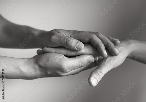 Hand holding another hand. People helping and comforting each other concept.

 photo