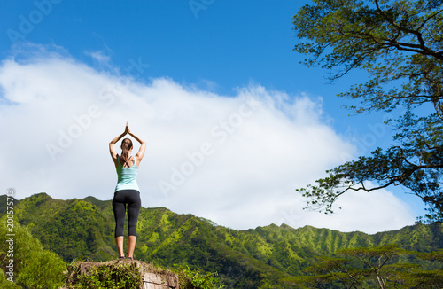 Woman doing meditation pose on a mountain. 