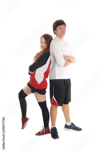 Young couple in sportswear standing back to back