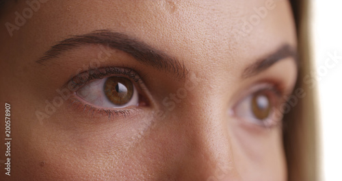 Obraz na plátne Close up of female millennial's eyes blinking on white background