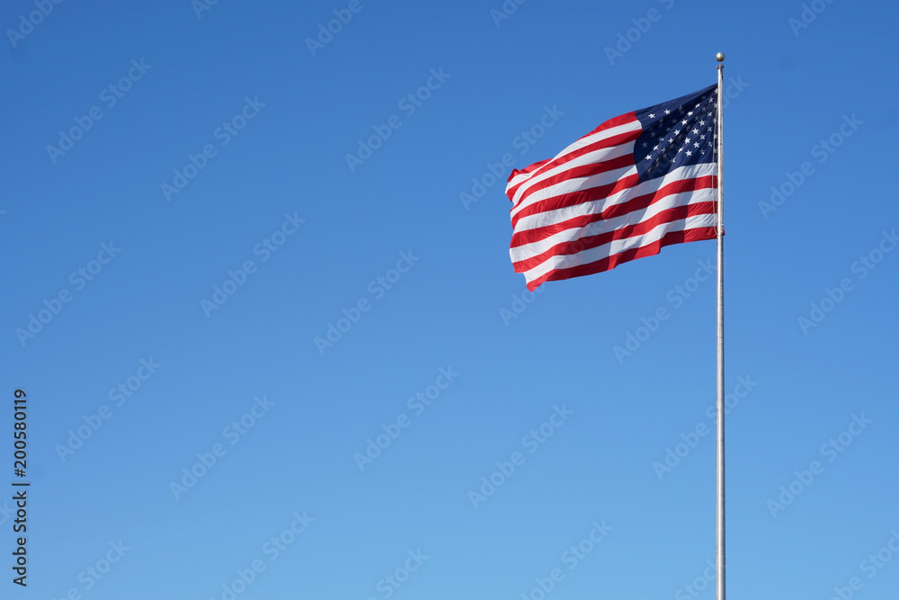 The American flag floats in the air proudly.                              