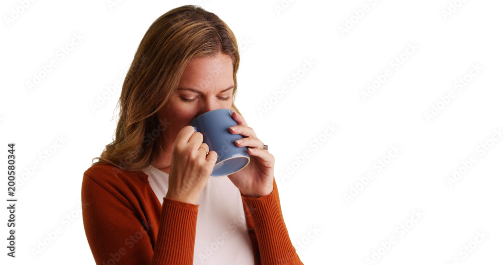 Middle aged Caucasian woman drinking coffee or tea smiling at camera Middle aged Caucasian woman drinking coffee or tea smiling at camera