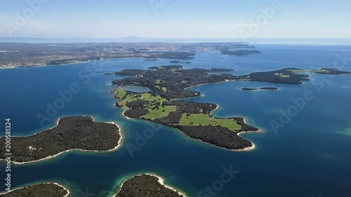 Flight over desert islands and colorful sea, Brijuni park, Croatia photo