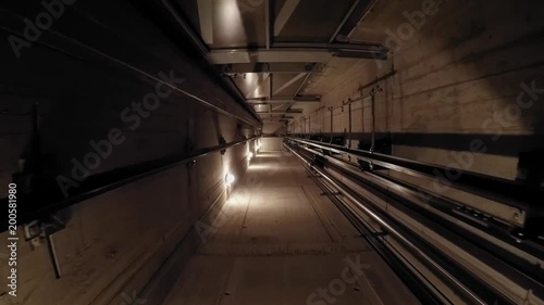 The cabin moves down in an elevator shaft. 02 The view is directed downwards. The camera is moving. The lights in the shaft give the ride its own rhythm.