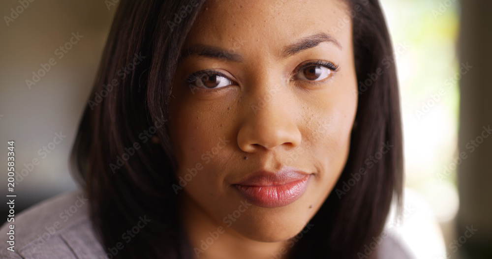 Tight shot of casual millennial African young lady's face in indoor setting Tight shot of casual millennial African young lady's face in indoor setting