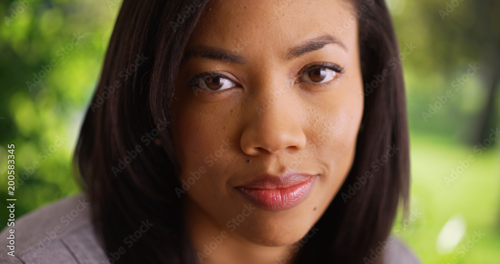 Close view of young black woman looking at camera in outdoor setting