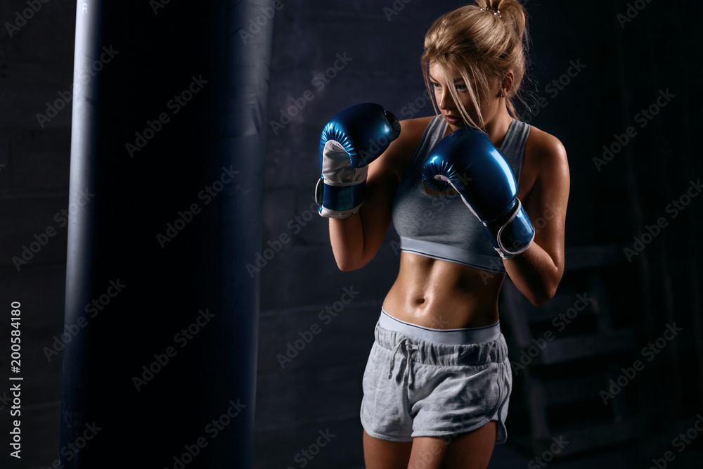 Sexy girl boxer trains in boxing hall
