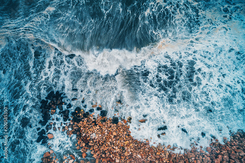 Aerial view of sea waves and rocky coast