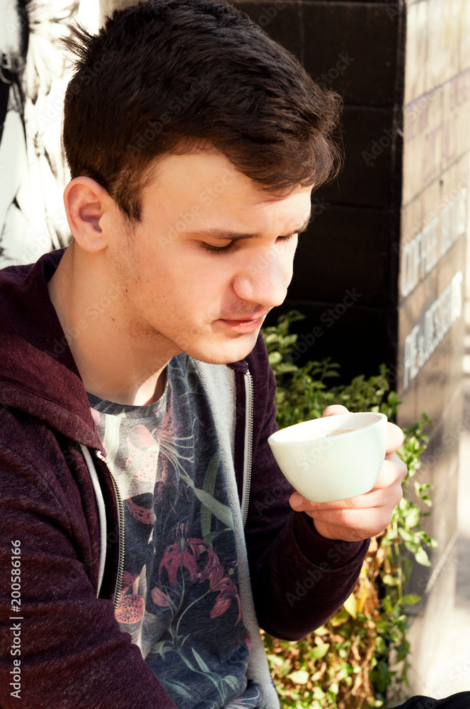 a young guy tries coffee on the palate in the street coffee shop espresso dopio a young guy tries coffee on the palate in the street coffee shop espresso dopio