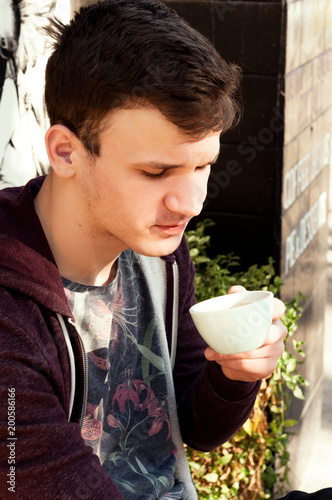 a young guy tries coffee on the palate in the street coffee shop espresso dopio photo