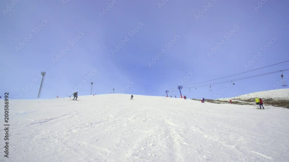 skiing man descends on a snowboard in sunny weather on a snowy slope skiing man descends on a snowboard in sunny weather on a snowy slope